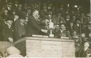 STANLEY SMITH (WAKEFIELD TRINITY) RECEIVING THE CHARITY CUP AT DEWSBURY 1920S - RUGBY LEAGUE POSTCARD